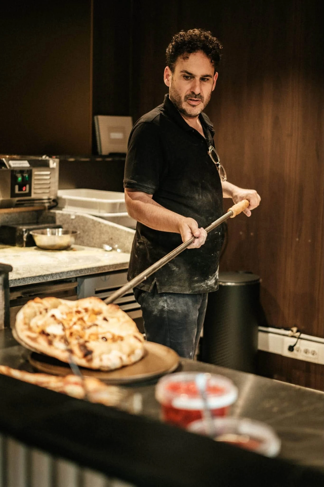 Le pizzaiolo sort une pizza du four